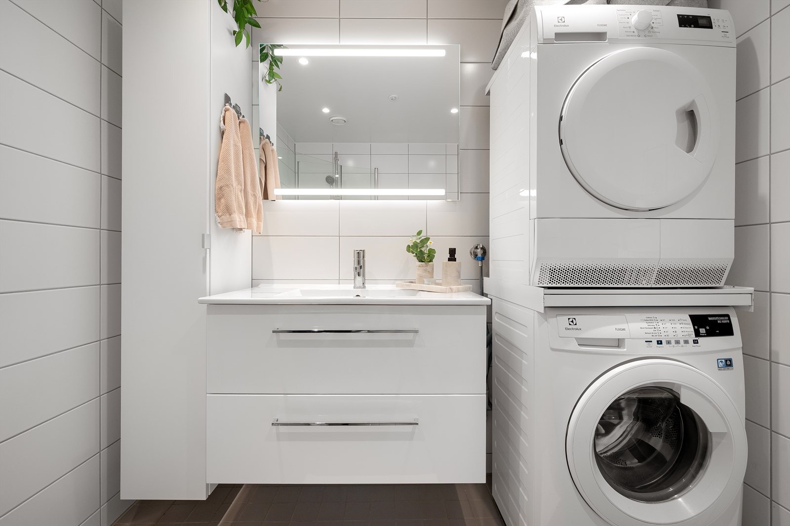 Praktisk baderom med god plass til vaskemaskin og tørketrommel, samt god oppbevaringsplass Galleribilde