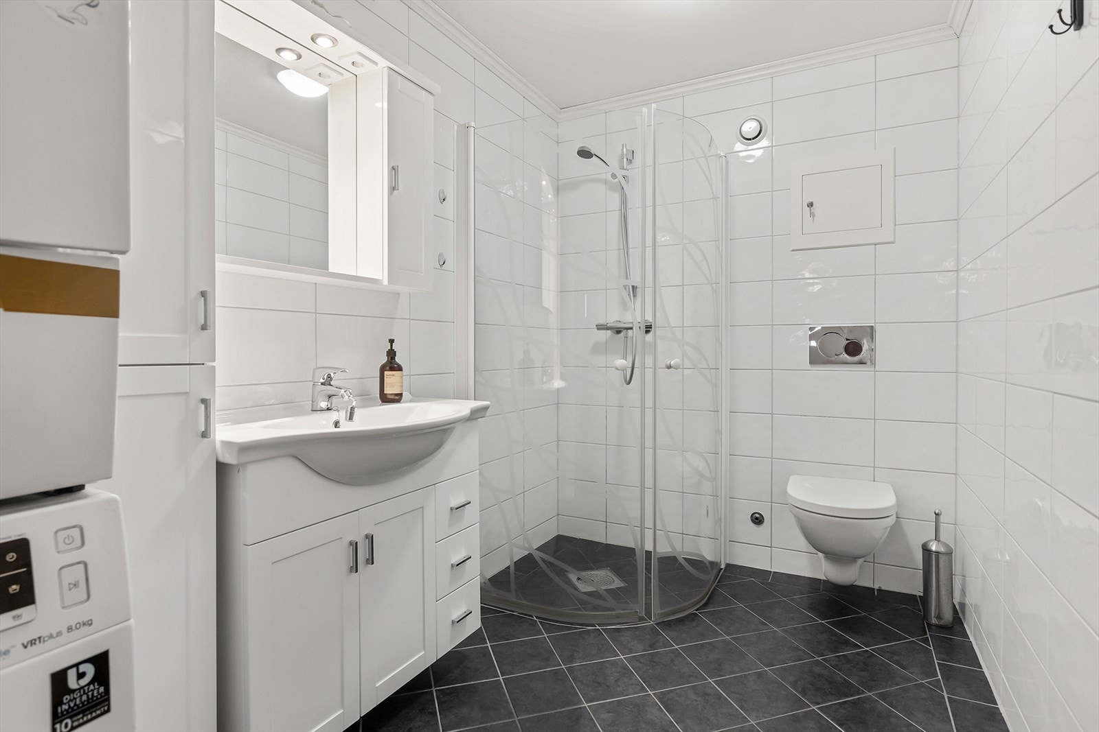 Pent bad med innfellbare dusjdører og vegghengt toalett Galleribilde