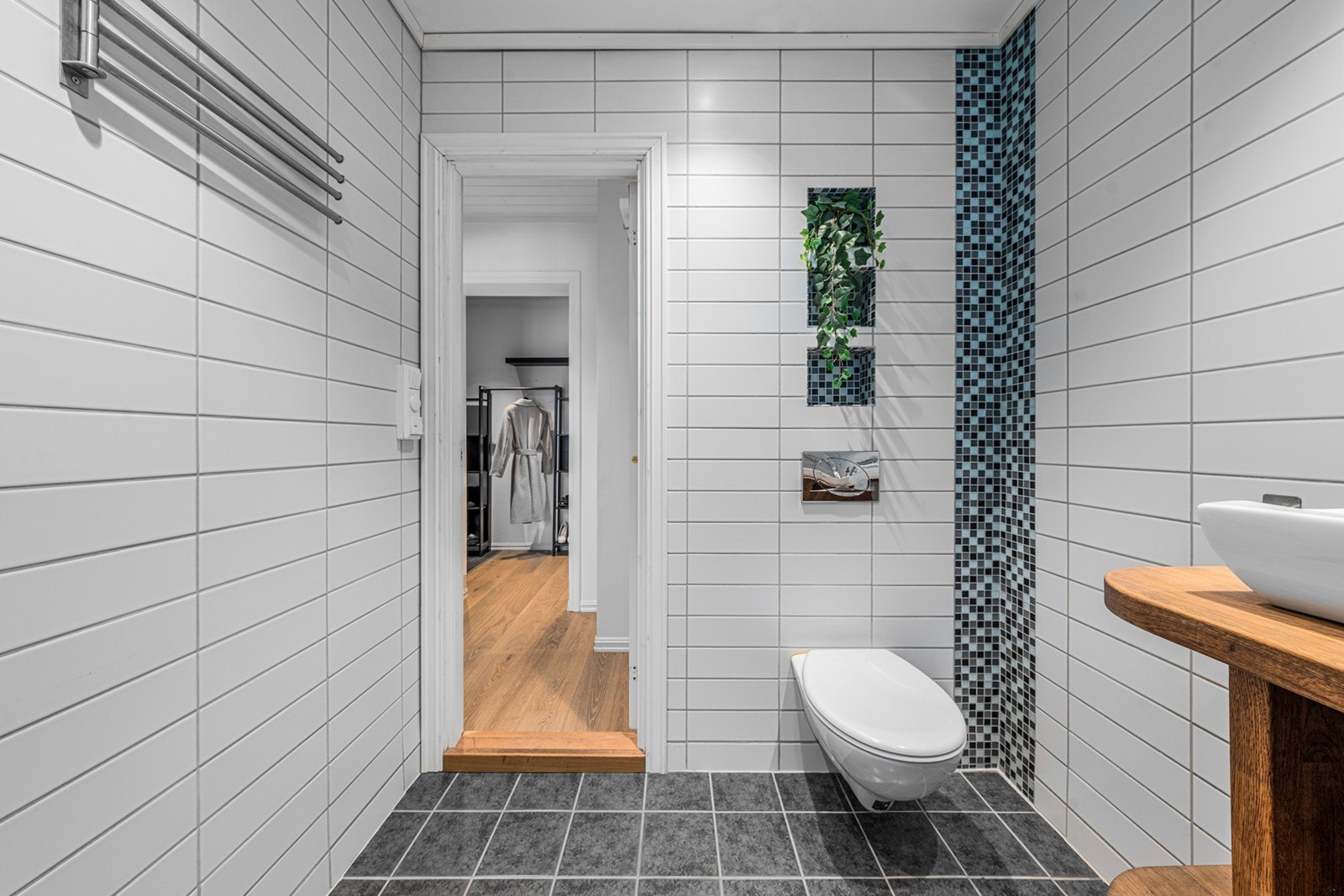 Vegghengt toalett og opplegg for vaskemaskin gir praktisk sanitærløsning. Galleribilde