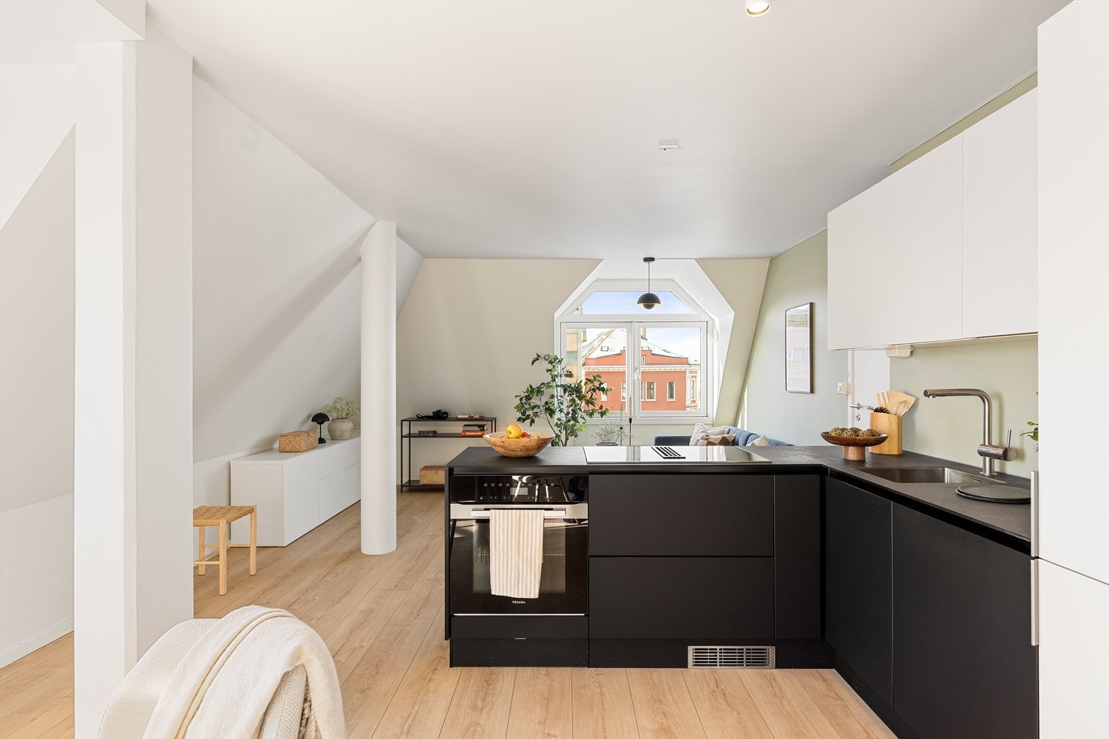 Det er en åpen stue/kjøkkenløsning som deler boligen inn i ulike sosiale soner. Galleribilde