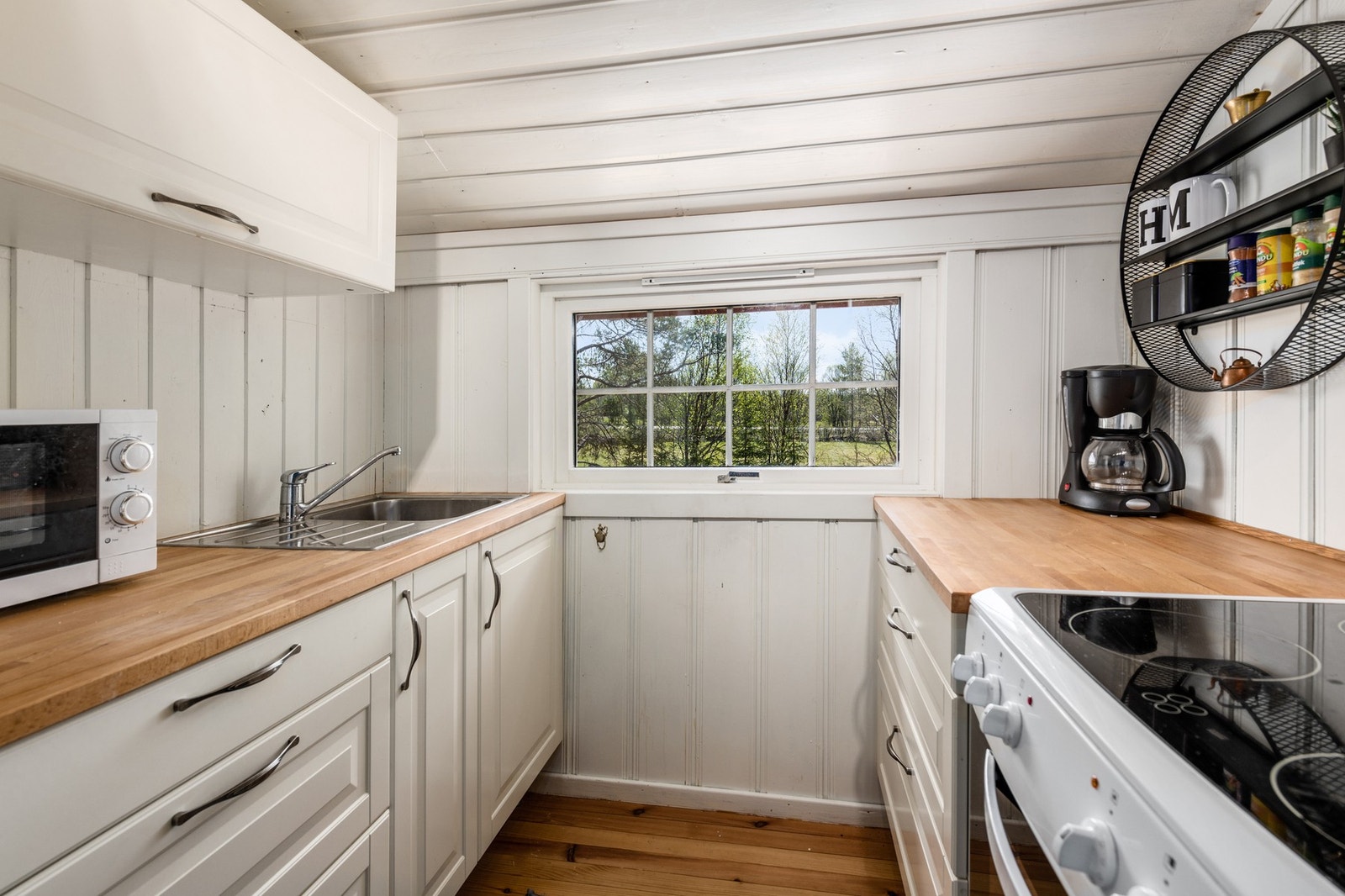 Kjøkkenet er innredet med skrog av laminat og profilerte skapdører, utført med benkeskap og overskap. Galleribilde