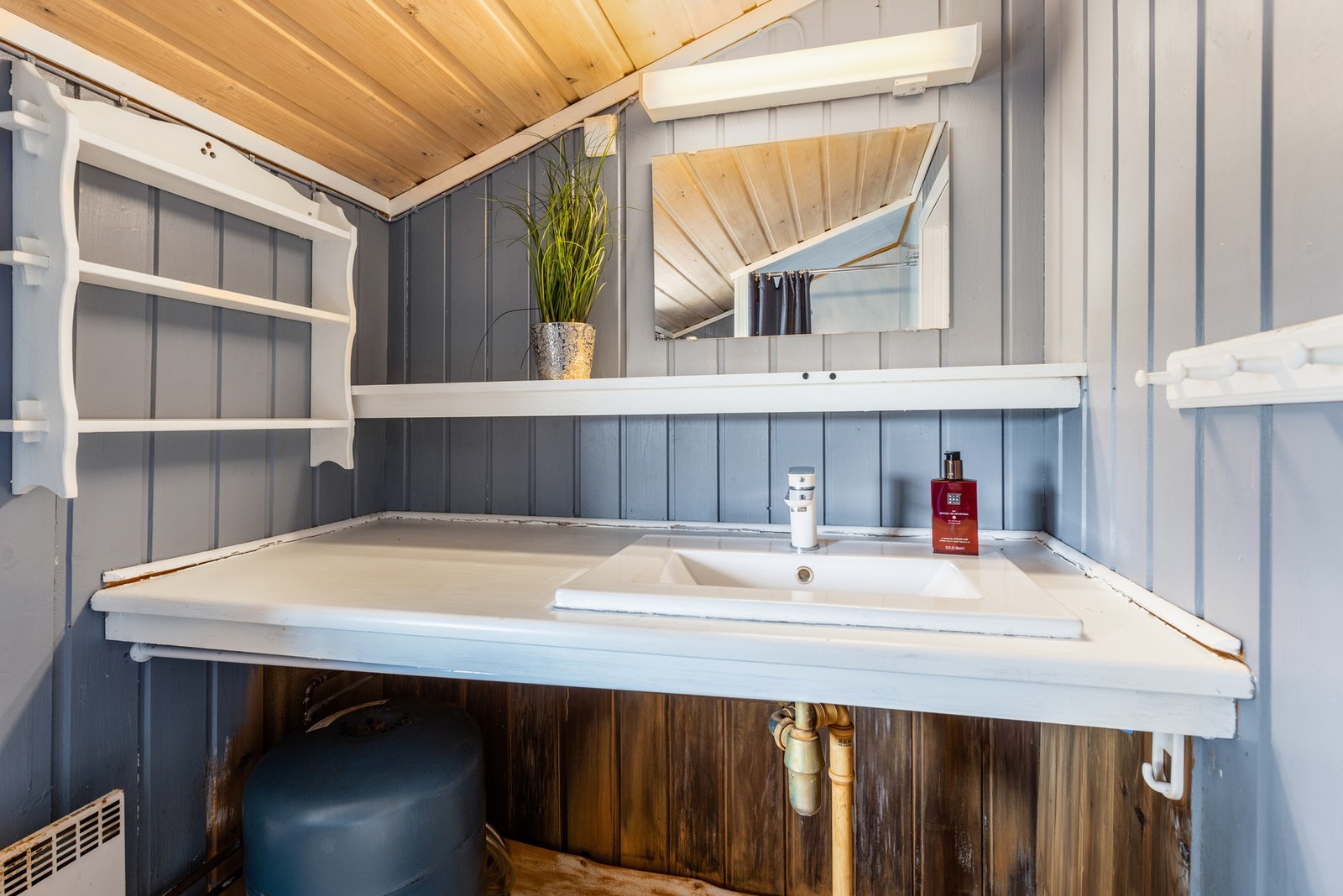 På badet er det montert diverse hyller og benkeplate i tillegg til servant og dusjhjørne. Galleribilde