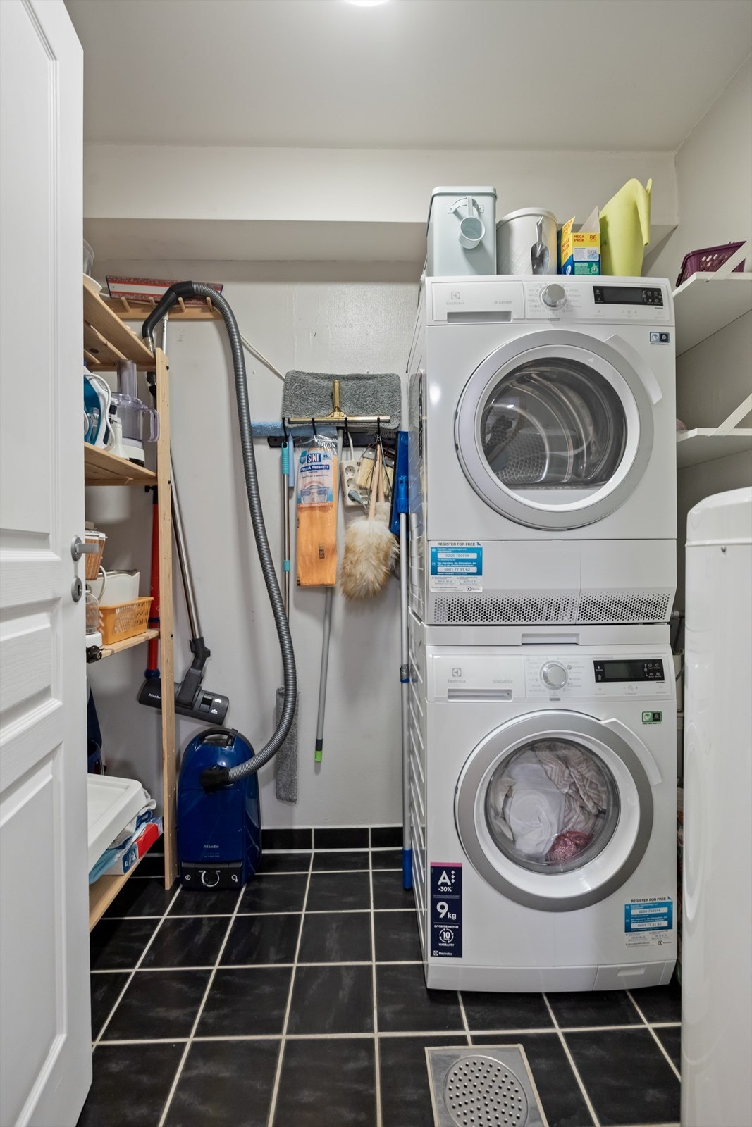 Separat vaskerom/bod med flislagt gulv og opplegg for vaskemaskin og plass til oppbevaring. Galleribilde