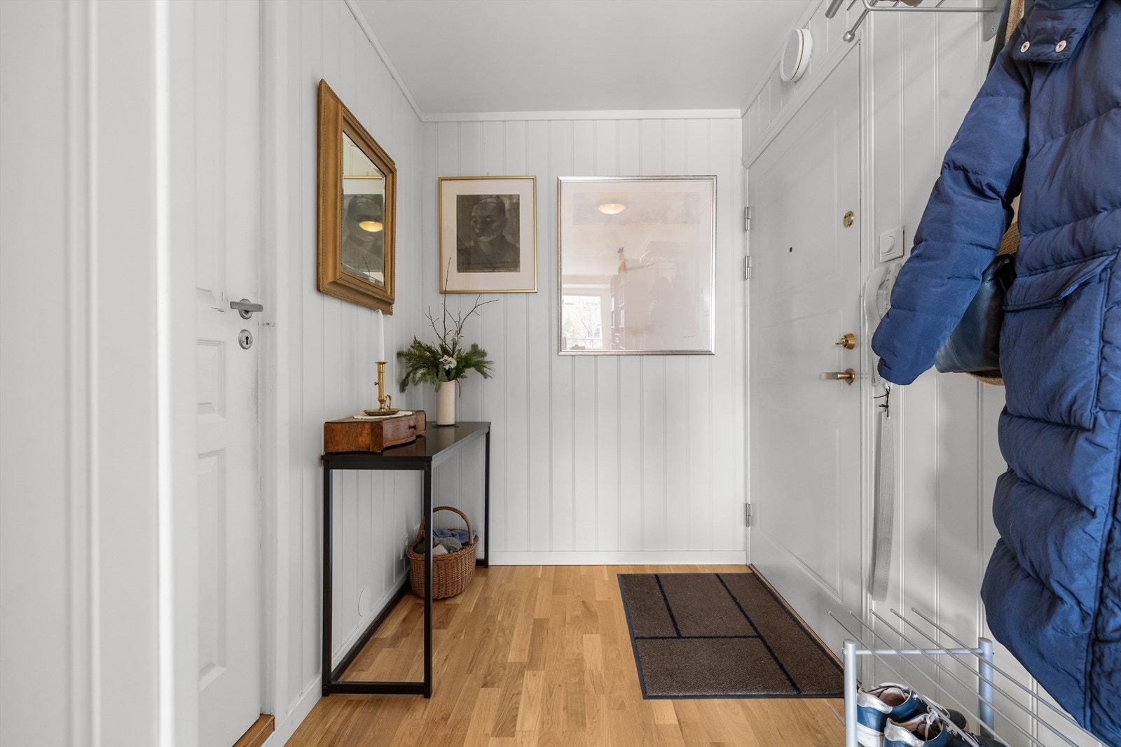 Lys entré med plass til å henge fra seg jakken før man går videre inn i leiligheten. Galleribilde