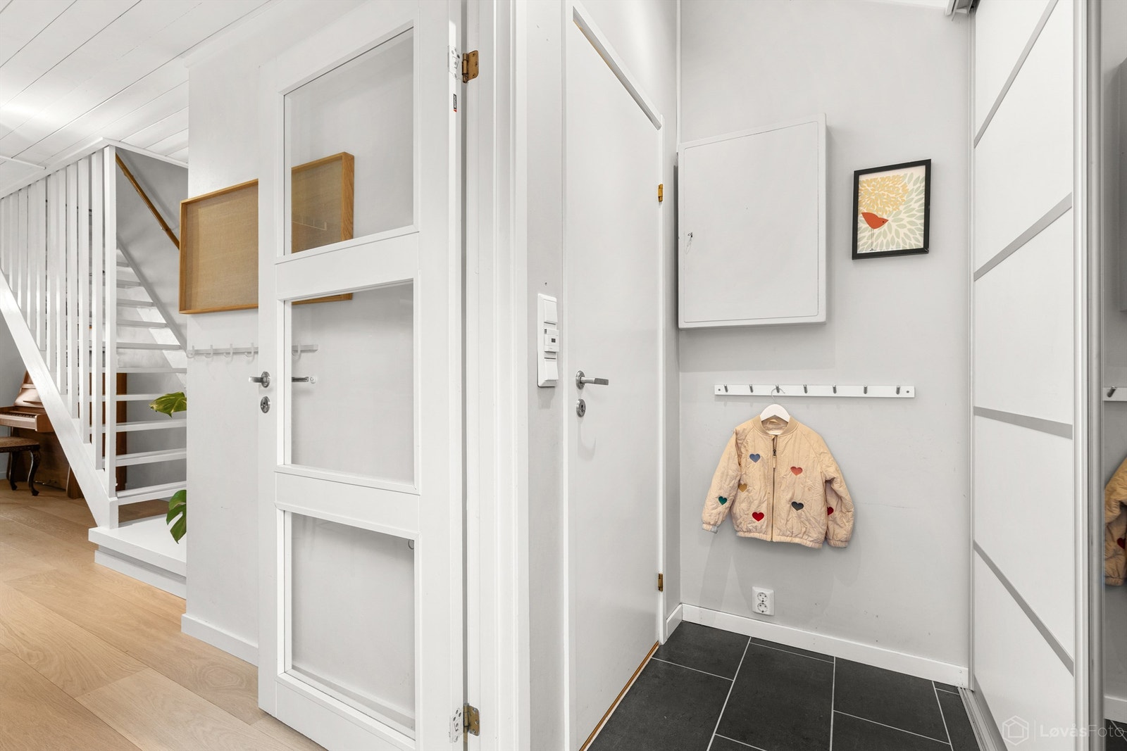 Entré med gulvfliser med varmekabler og praktisk skyvedørsgarderobe med god plass til yttertøy Galleribilde