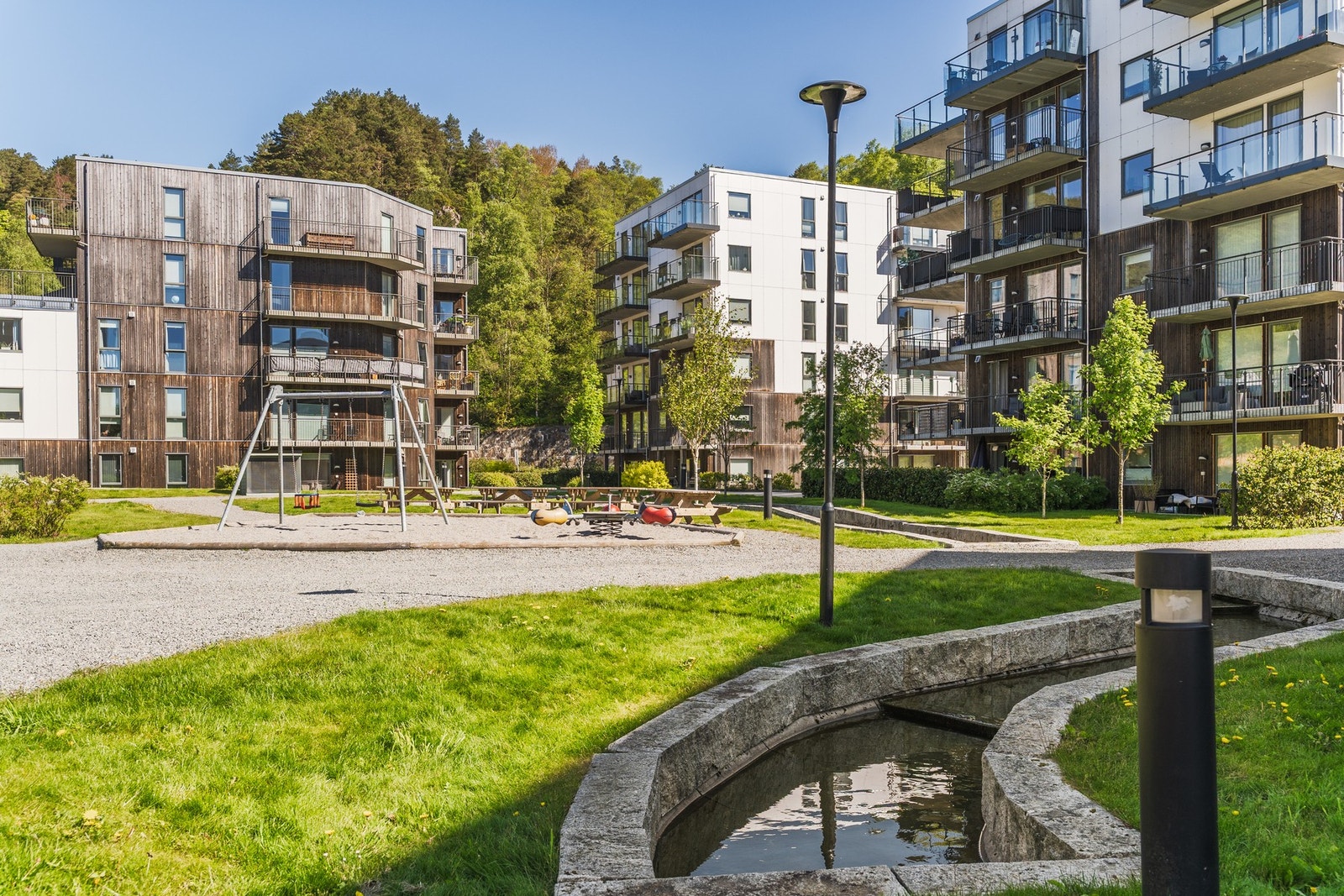 Flott felles uteområder med grøntområder og benker Galleribilde