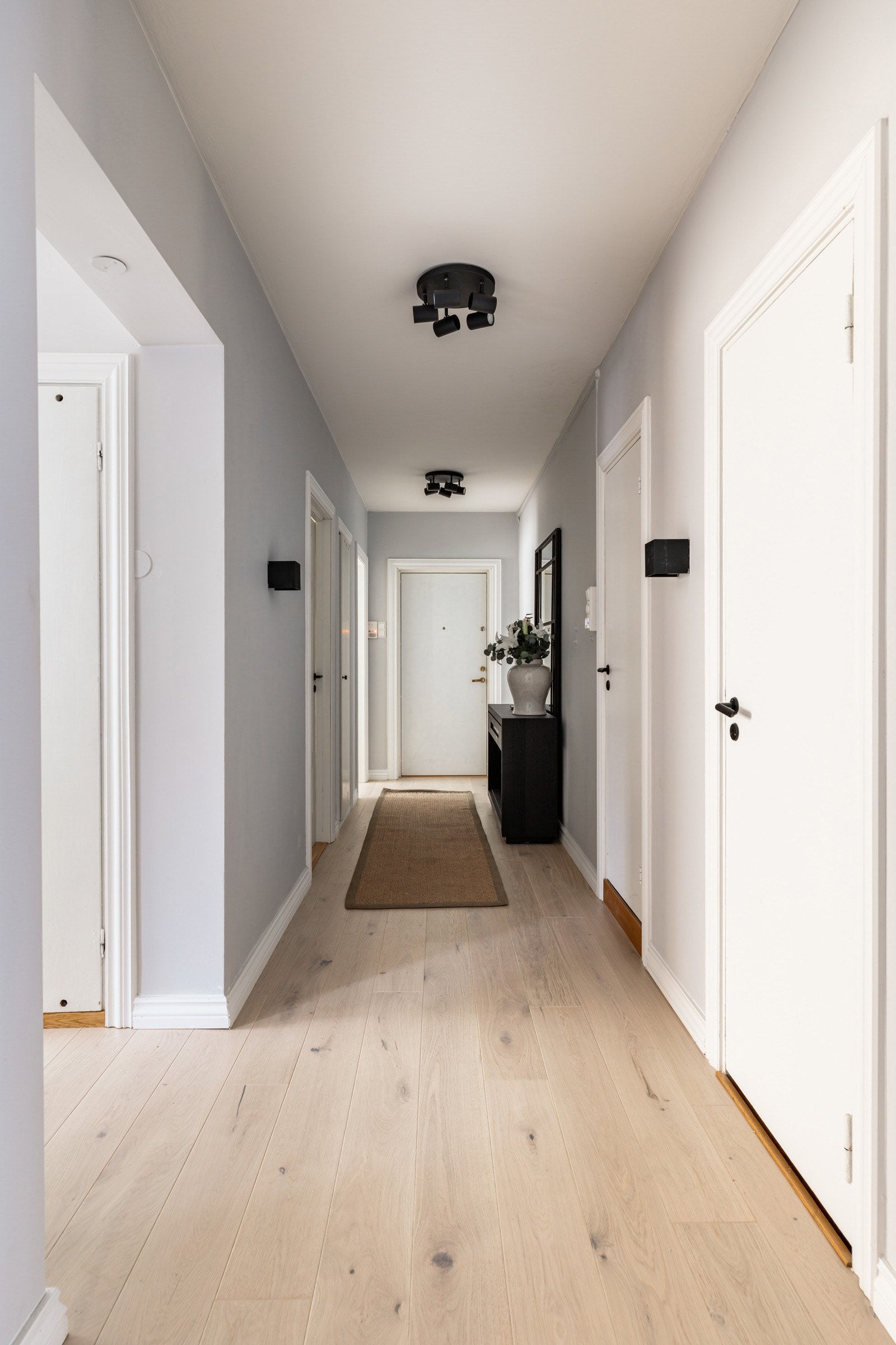 Entréen er innbydende med lysegrå veggflater, hvitmalt himling og ny eikeparkett på gulv fra 2025. Galleribilde