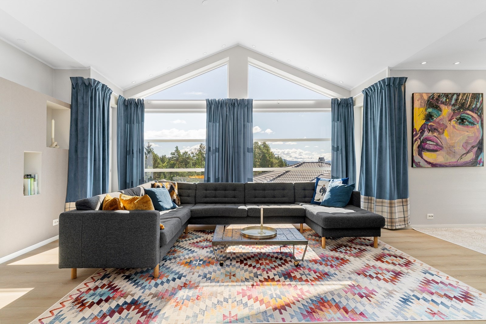 Rommets åpne utforming gir gode møbleringsmuligheter, med plass til både en stor sofagruppe og personlige interiørvalg. Galleribilde