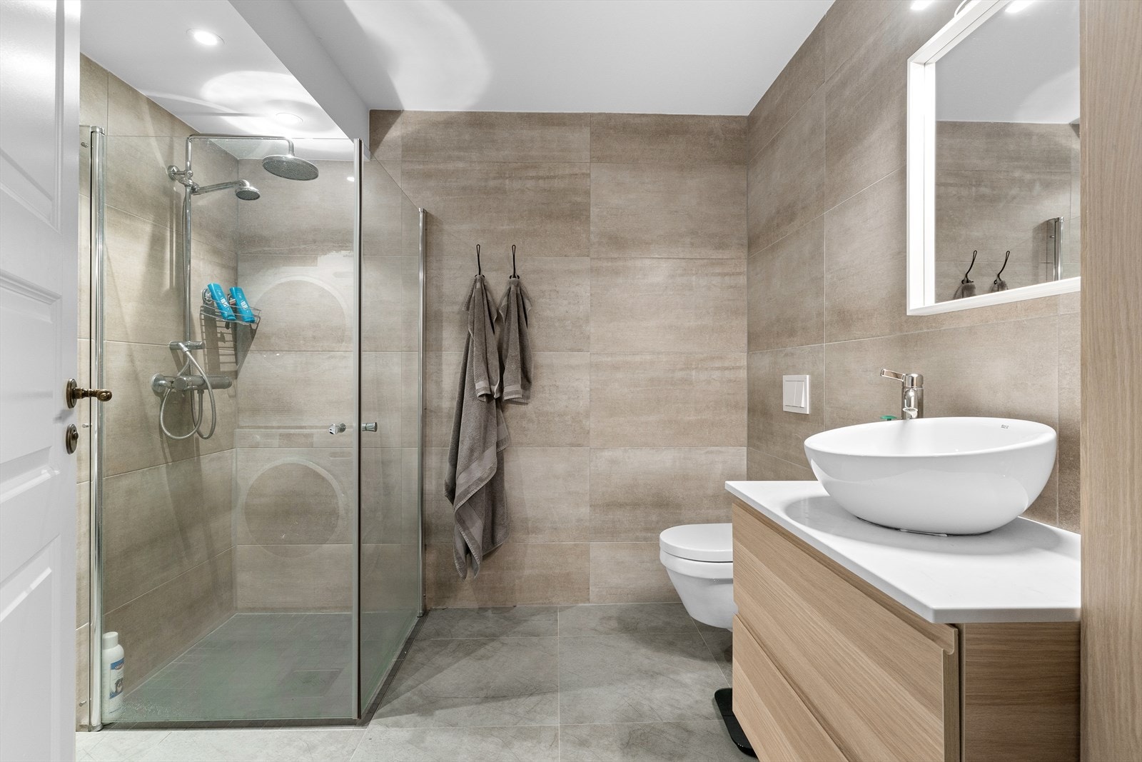 Pent innredet bad i hybelen. Badet er utstyrt med dusjhjørne, vegghengt toalett og bolle servant og speil. Galleribilde