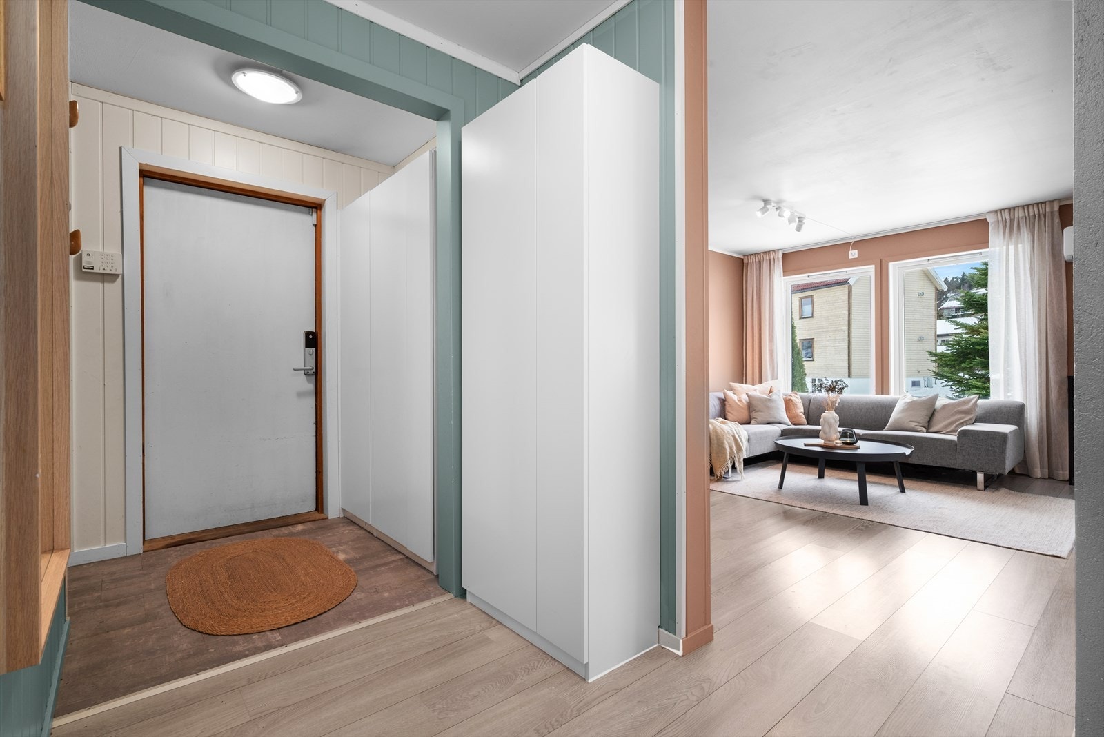 Boligens innbydende entré/gang på 11 kvm, har godt med plass til både yttertøy og sko i to stilrene og praktiske garderobeskap. Galleribilde