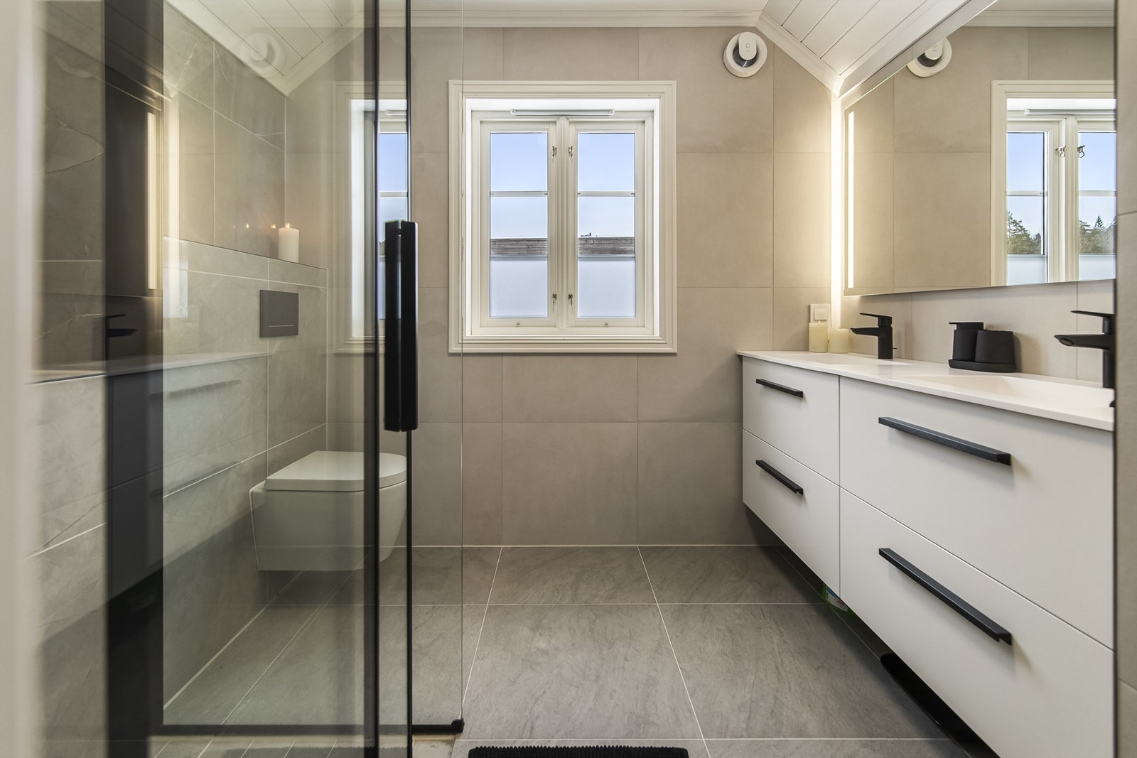 Romslig og delikat bad med stor dusjnisje og wc. Galleribilde