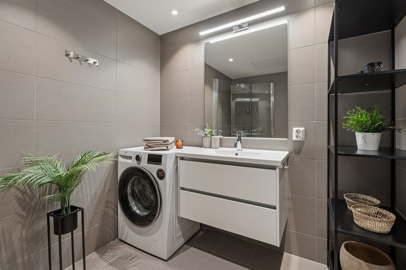 Heldekkende servant med skuffeseksjon. Downlights i taket og lys over speilet. Galleribilde