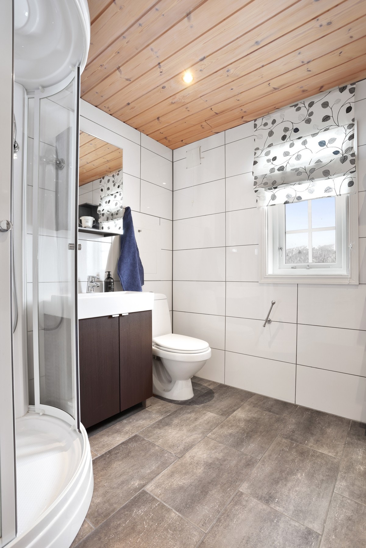 Hytta har 2 fine bad. Her er bad I med flislagte overflater og inngang til en deilig badstue Galleribilde