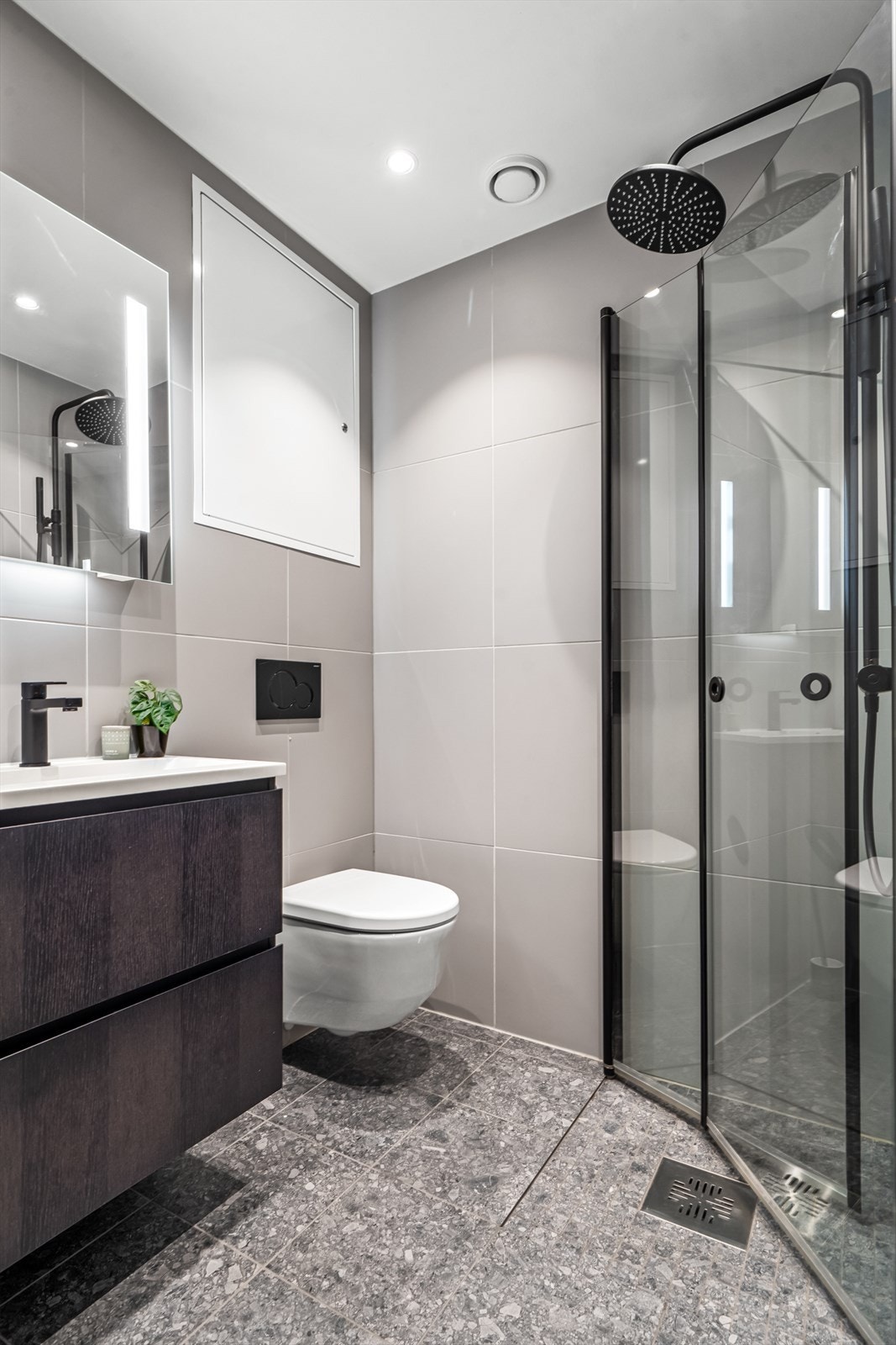 Stilfult baderom ll med vegghengt WC, servant og dusjhjørne. Galleribilde