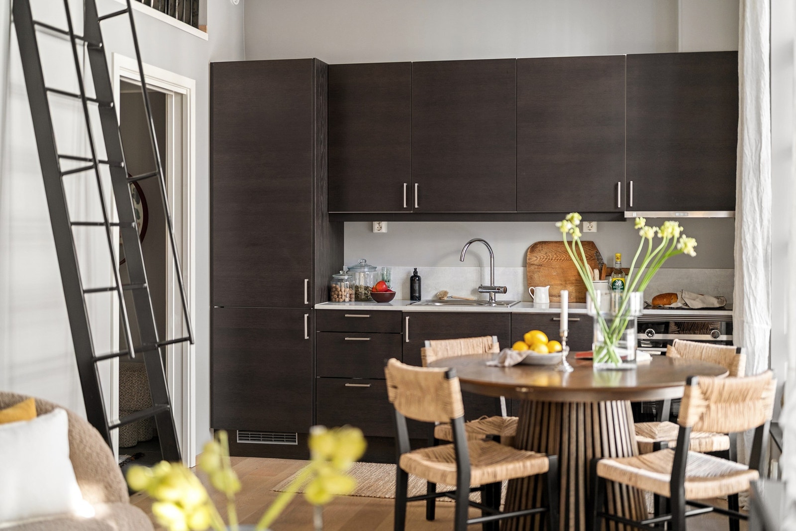 Den åpne løsningen mot stue og spiseplass skaper en sosial og innbydende atmosfære, hvor de store fabrikkvinduene gir rikelig lys og en unik romfølelse. Galleribilde