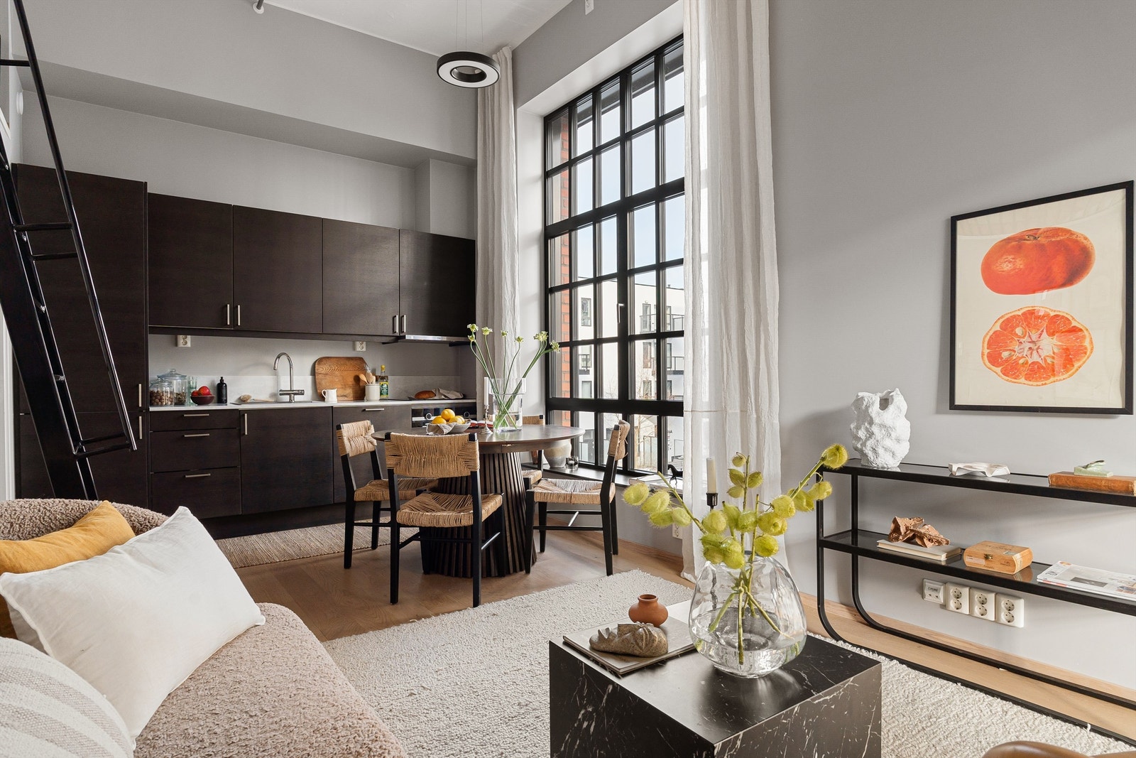 De generøse vindusflatene, kombinert med den åpne planløsningen mot kjøkkenet, skaper en romfølelse utenom det vanlige og gir boligen et tydelig industrielt preg. Galleribilde