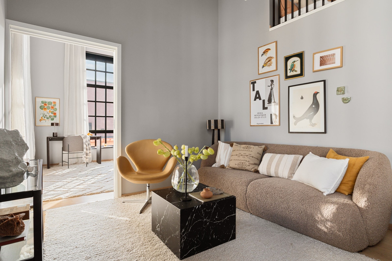 Stuen fremstår som lys og luftig med imponerende takhøyde og store, karakteristiske fabrikkvinduer som slipper inn rikelig med naturlig lys. Galleribilde