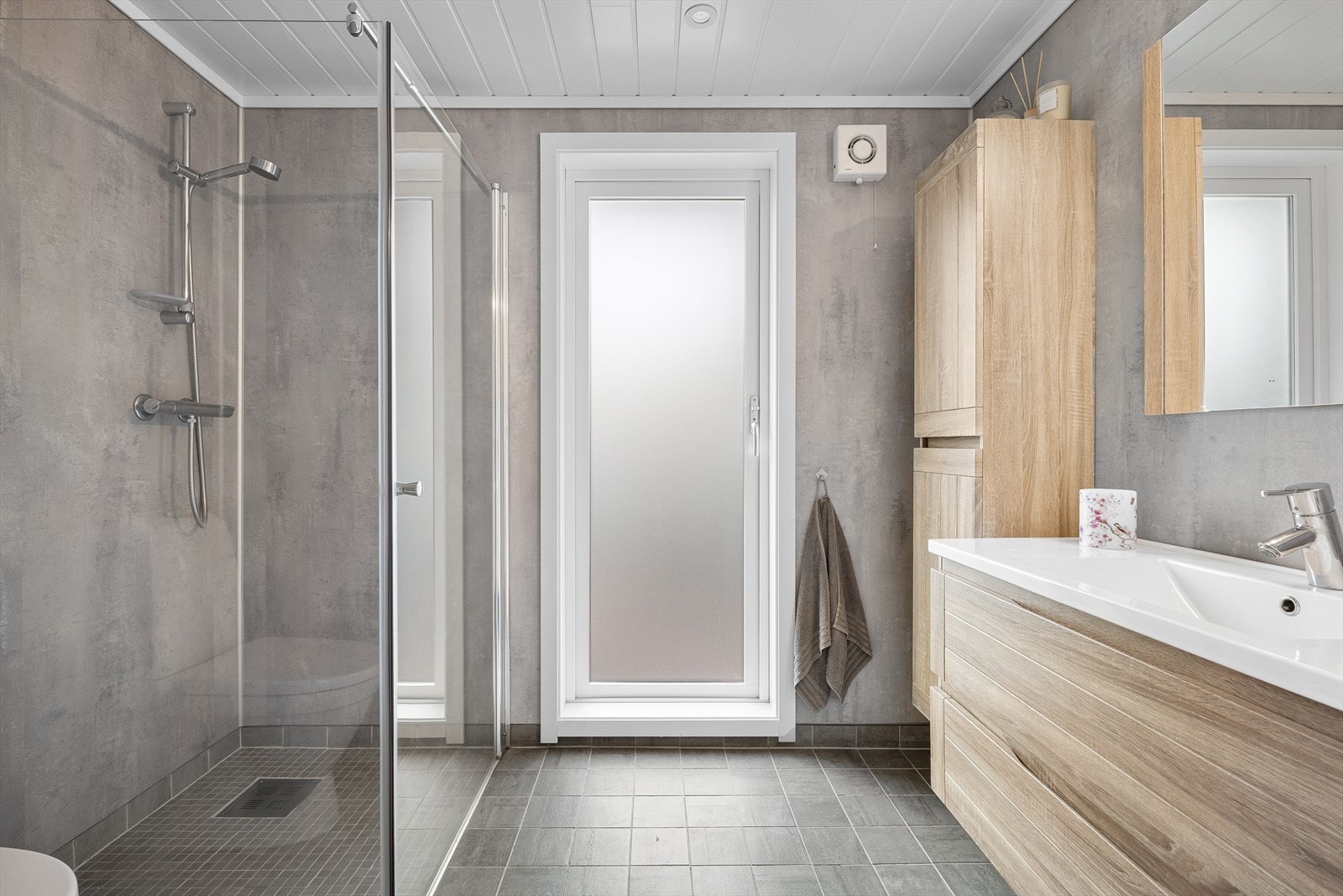 Badet er romslig og inneholder innredning med servant, toalett og dusj Galleribilde