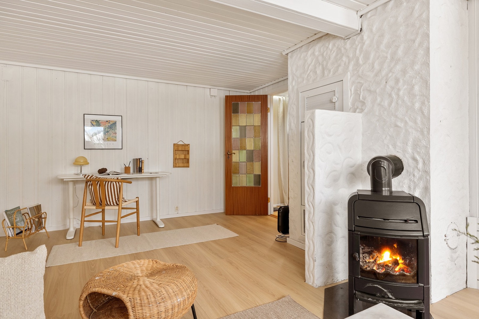 Kjellerstuen er innredet med pult, sofa og peis. Galleribilde