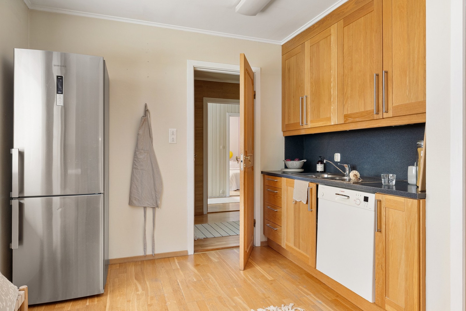 Kjøkkenet har innredning med eik profilerte fronter og laminat benkeplate med nedfelt vask av stål. Av integrerte hvitevarer er det stekeovn, platetopp, oppvaskmaskin og ventilator. Galleribilde