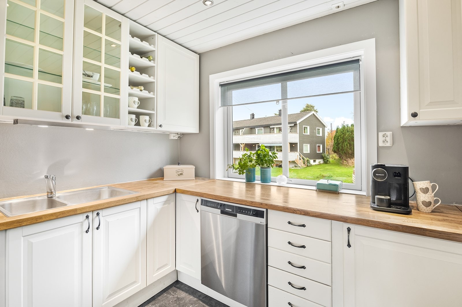 Kjøkkeninnredningen har god skapplass, med blant annet vitrineskap for ekstra oppbevaring. Galleribilde