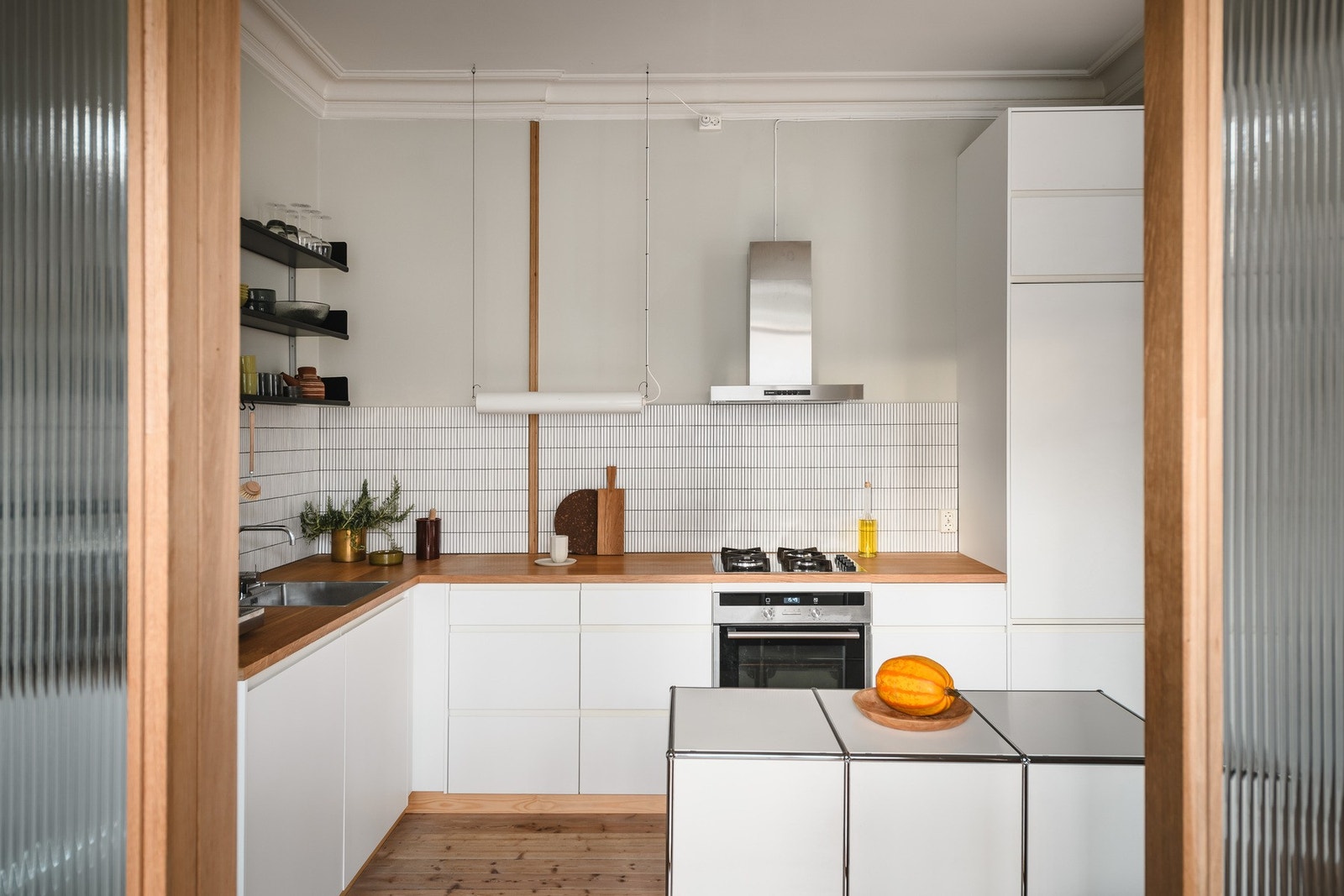 Kjøkkenet har integrerte hvitevarer, gass koketopp og solide benkeplater i heltre eik. En arkitekttegnet skillevegg i eik og glass adskiller kjøkkenet fra et av soverommene. Galleribilde