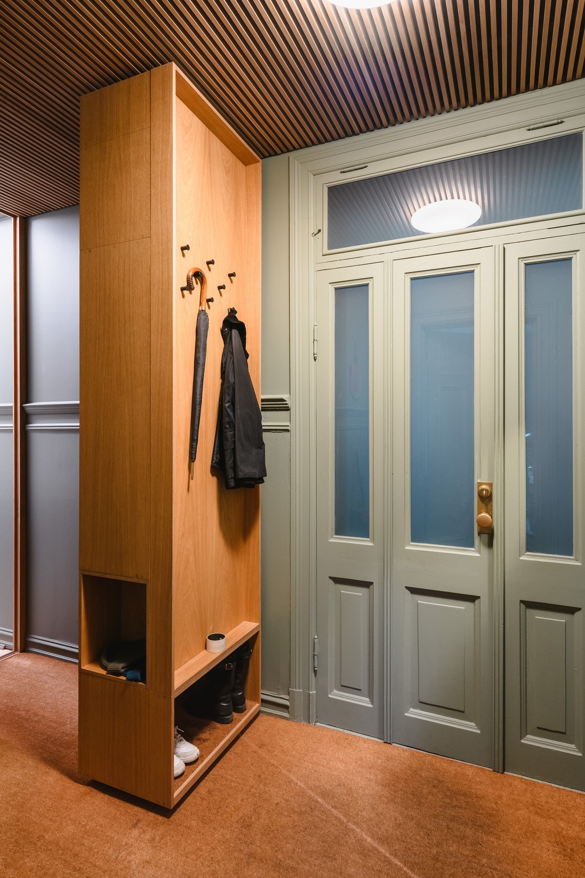 Innbydende entré med snekkerbygd garderobe, spilehimling og slitesterkt kokosteppe på gulvet. Galleribilde