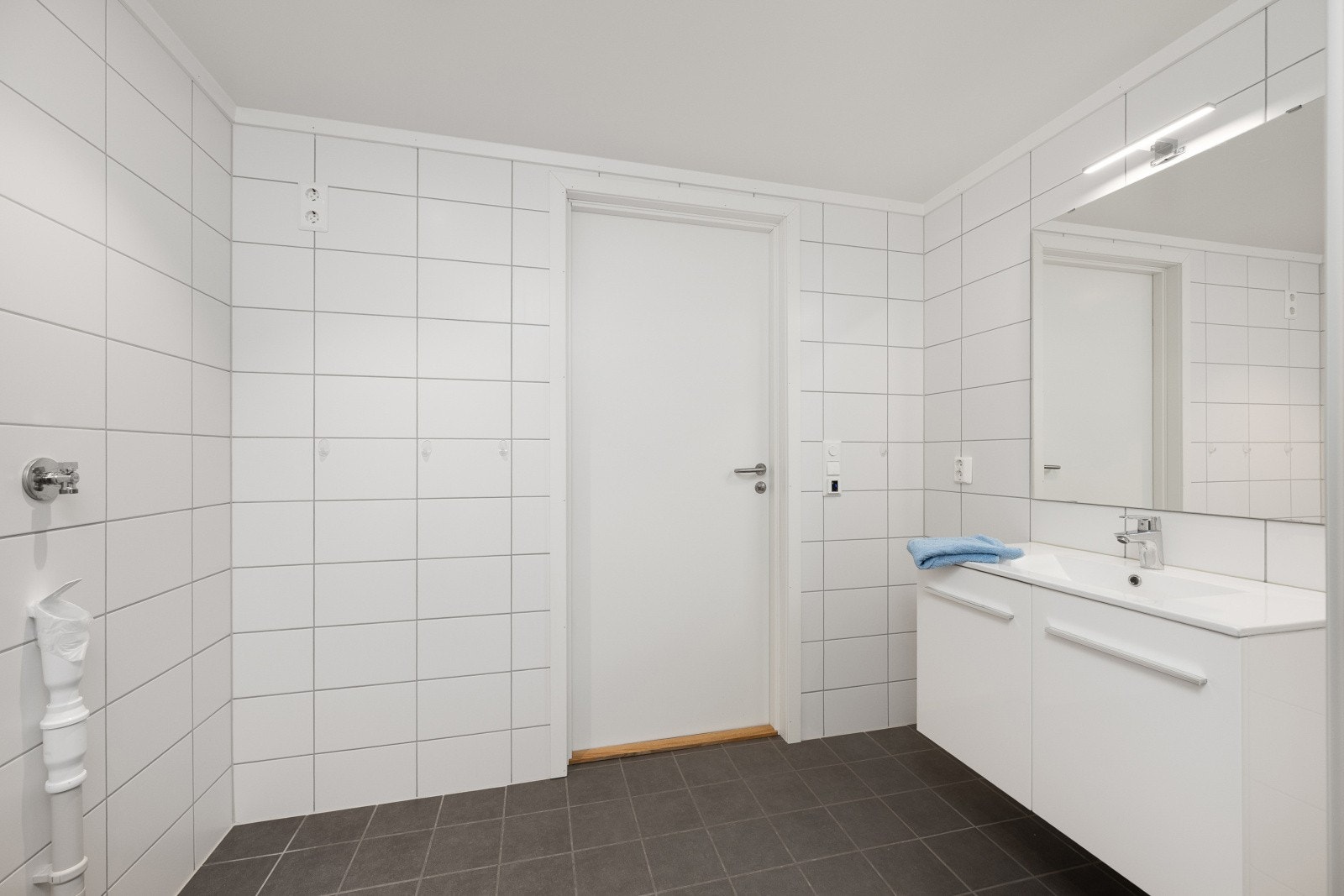 Et delikat bad med nøytrale fliser. Varmekabler. Himling med innfelte downlights. Galleribilde