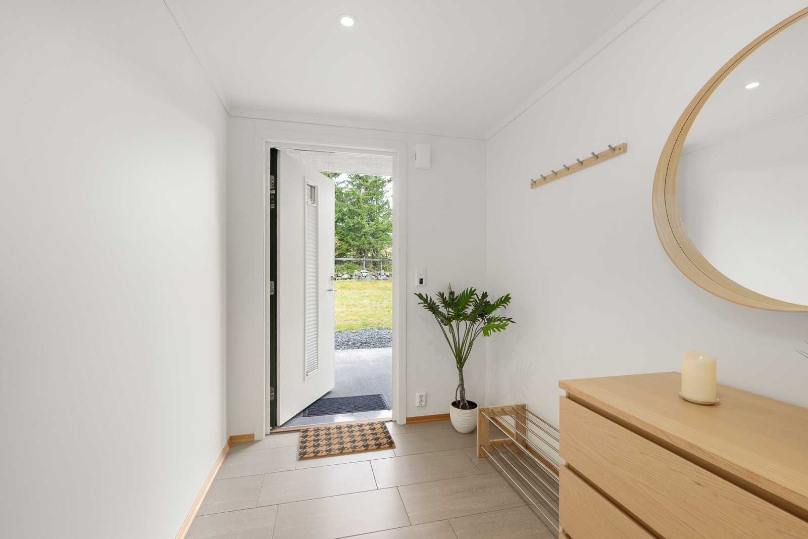 I entréen er det flislagt gulv med varmekabler. Fint lysinnslipp fra glassfelt i ytterdøren. Galleribilde