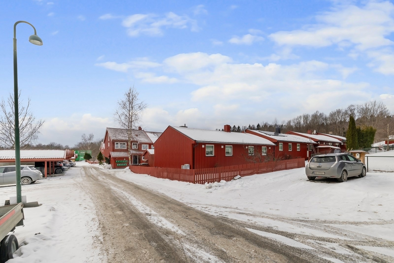 Med boligen følger parkeringsplass langs gjerdet. Stor nok til to biler etter hverandre. Galleribilde