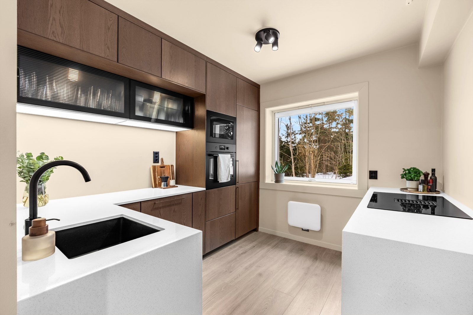 Det er godt med skap- og benkeplass. Kjøkkenet har trivelig utsyn mot lite skogholt. Galleribilde