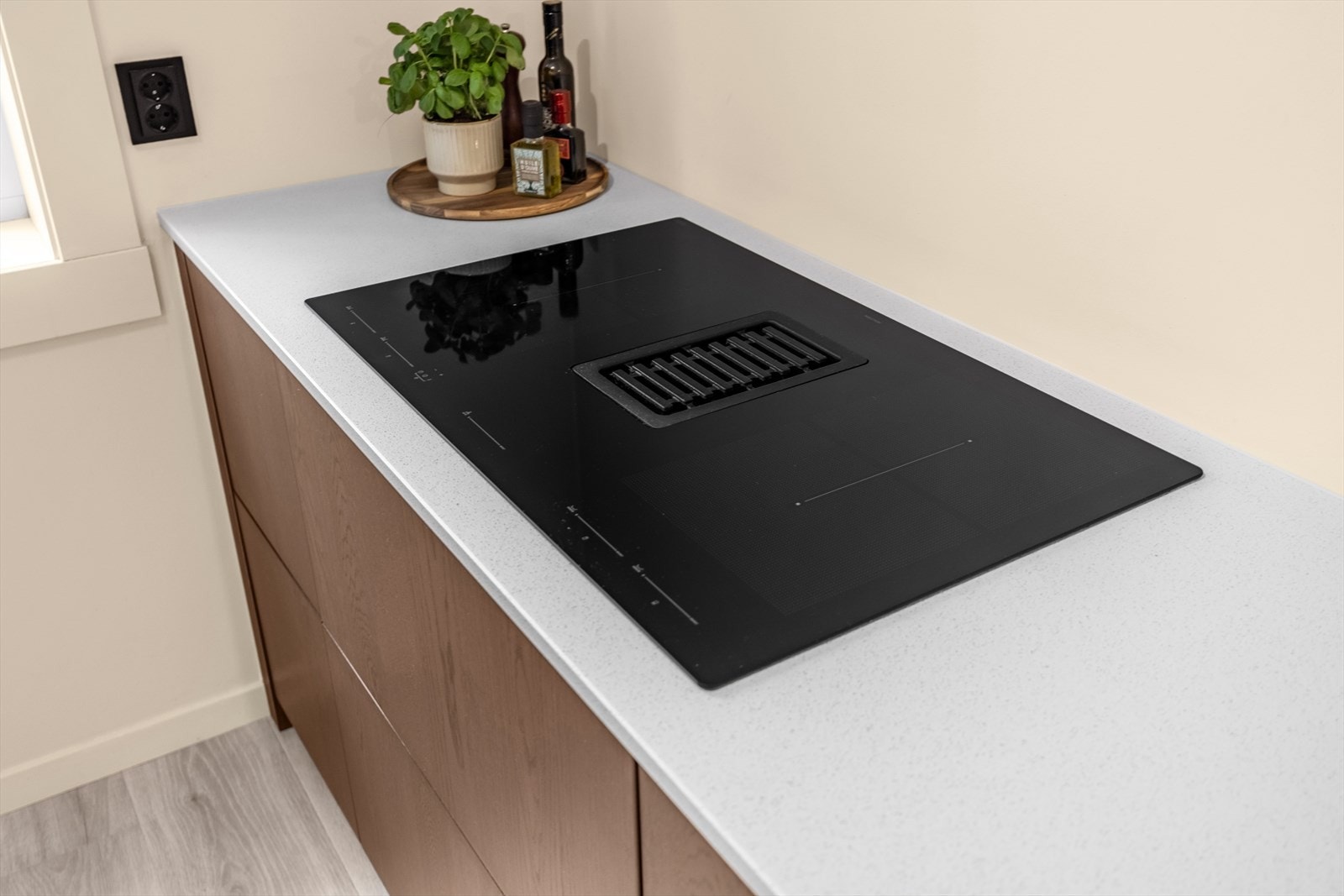 Påkostede detaljer som benkeplate av stein(Kvartskompositt) med underlimt vaskekum og stor induksjoinstopp med integrert ventilator. Det er montert komfyrvakt. Galleribilde