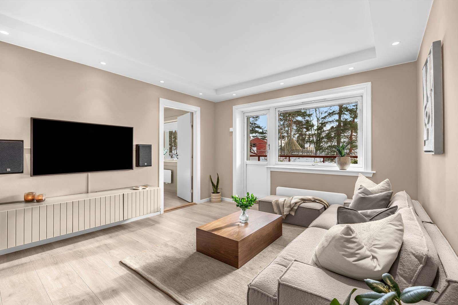 En hyggelig stue med moderne peisovn, store vindusflater fra 2011 og nedsenket spottkasse som skaper fine lysforhold. Galleribilde