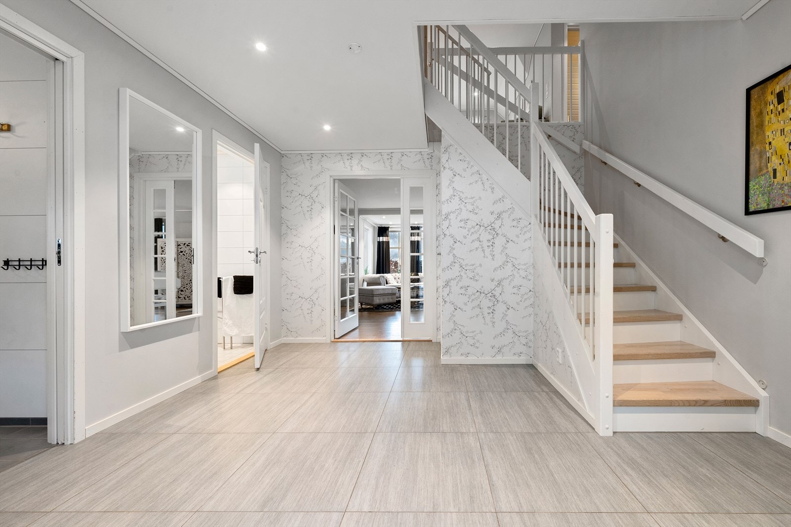 Romslig, flislagt hall i boligens 1. etasje. Galleribilde