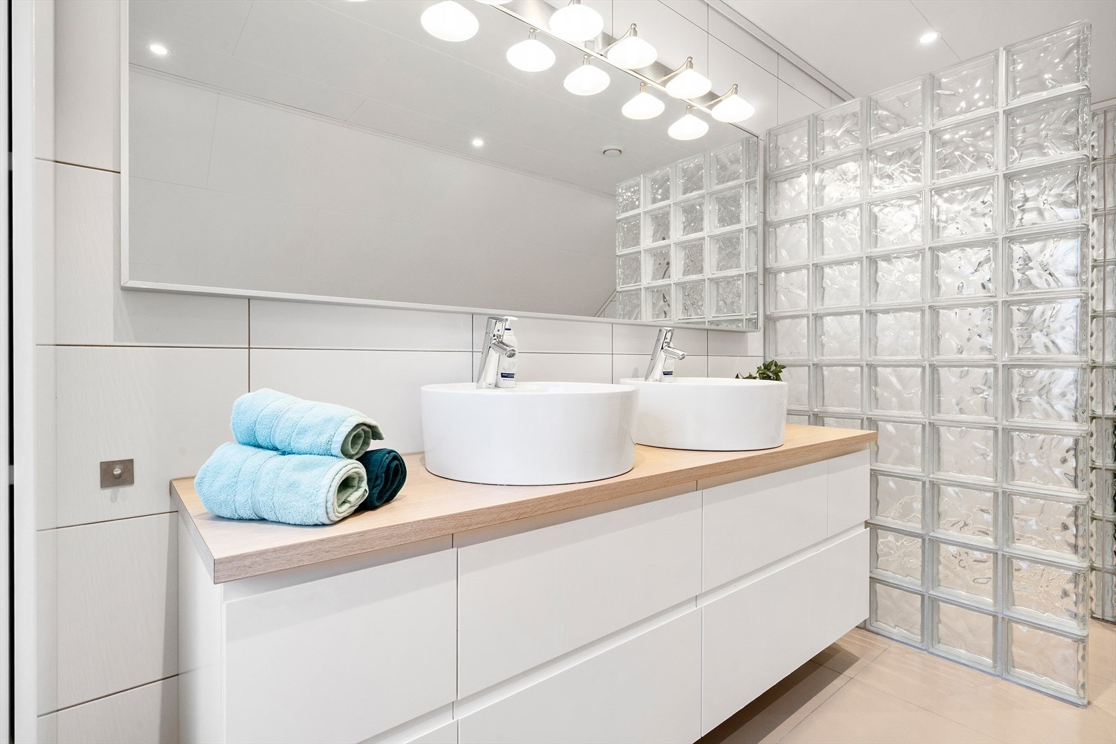 Det er utstyrt med vegghengt toalett, baderomsinnredning med dobbel servant, dusj med vegg av glassbyggerstein og badekar. Galleribilde