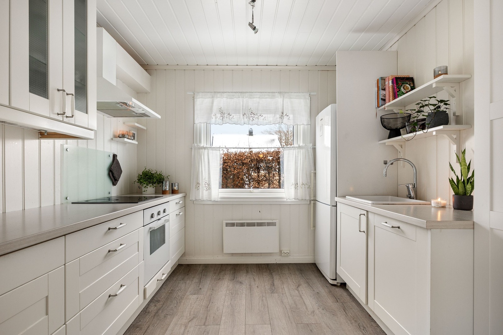 Lyst og praktisk kjøkken med god benkeplass og oppbevaringsmuligheter. Effektivt for matlaging og oppbevaring. Galleribilde