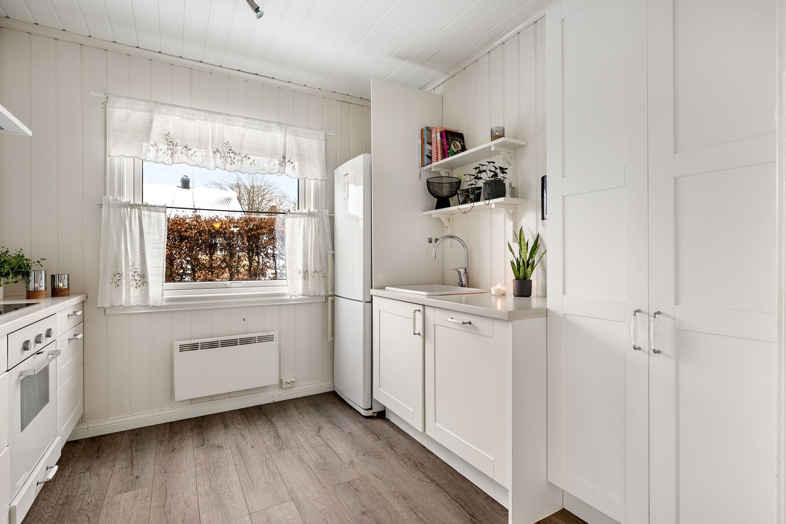 Pen kjøkkeninnredning med prifilerte fronter. Integrert komfyr og oppvaskmaskin. Galleribilde