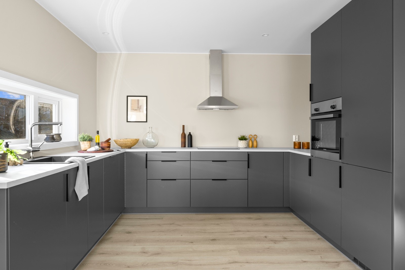 Innredningen leveres fra Drømmekjøkkenet og har lys grå, slette fronter og laminat benkeplate. Galleribilde