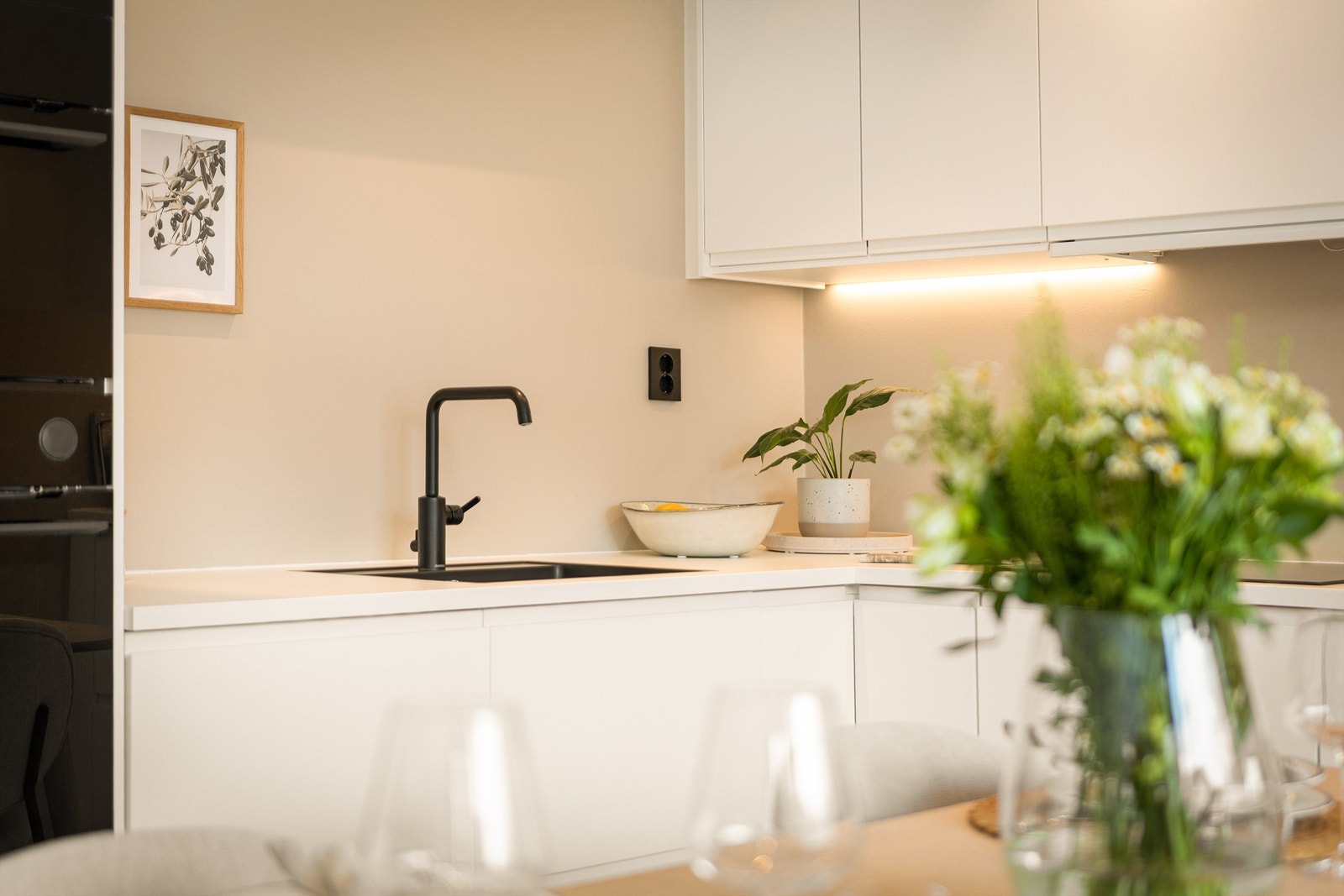 Kjøkkenet har flotte svarte detaljer kombinert med en klassisk farge med innfreste håndtak Galleribilde