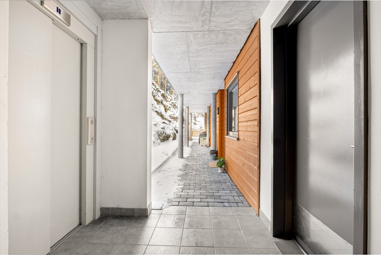 Leiligheten ligger i en høy første etasje med umiddelbar tilkomst fra garasje på høyre side. Galleribilde