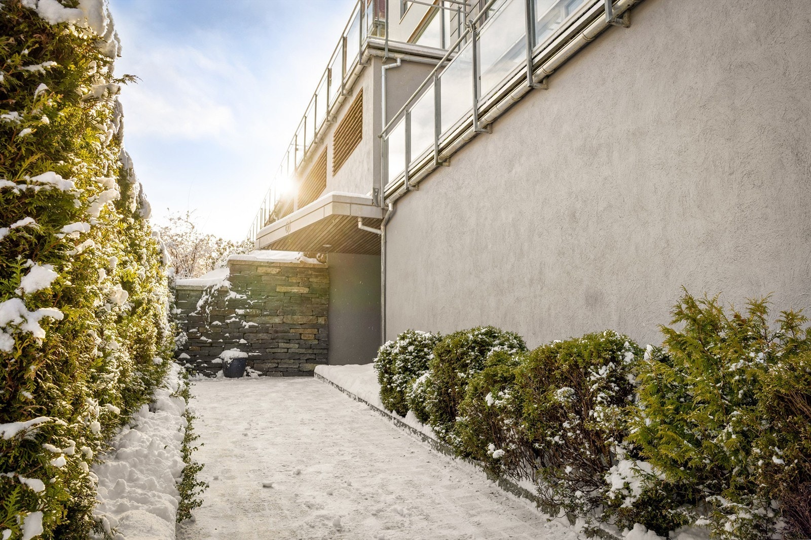 Elegant inngangsparti med fasadestein og grønne omgivelser Galleribilde