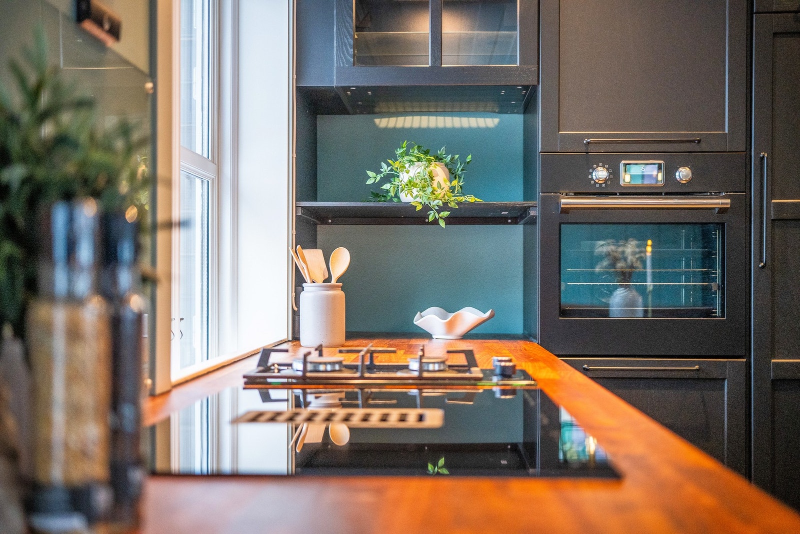 Kjøkkenet inneholder kjøleskap, oppvaskmaskin, stekeovn og platetopp med ventilator. Galleribilde