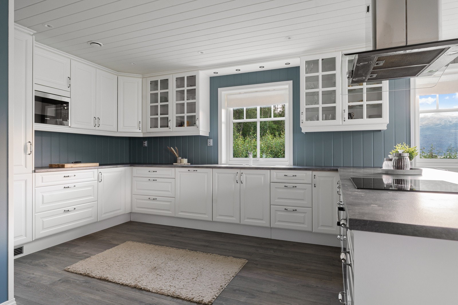 Lyst kjøkken med profilerte fronter. Integrerte hvitevarer og godt med oppbevaringsplass i over- og underskap. Galleribilde