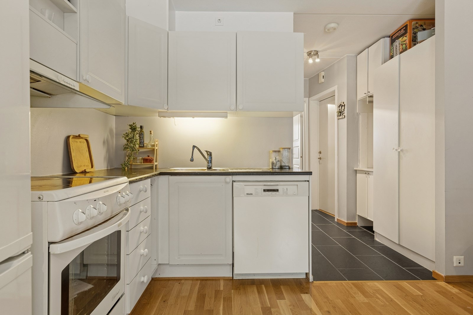 Kjøkkenløsningen gir plass til det nødvendige av hvitevarer og god oppbevaringsplass Galleribilde