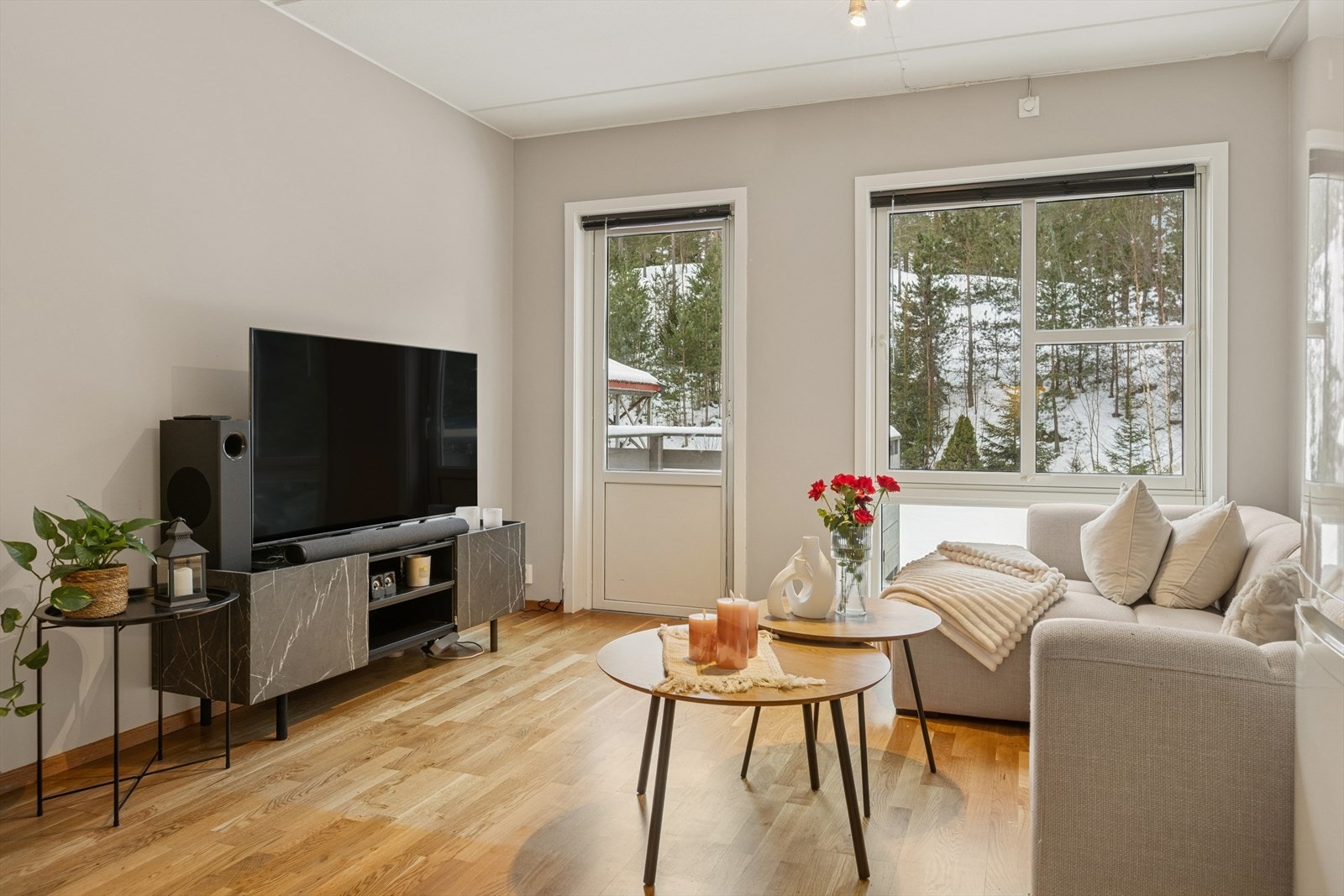 Luftig stue med store vinduer mot grønne omgivelser Galleribilde