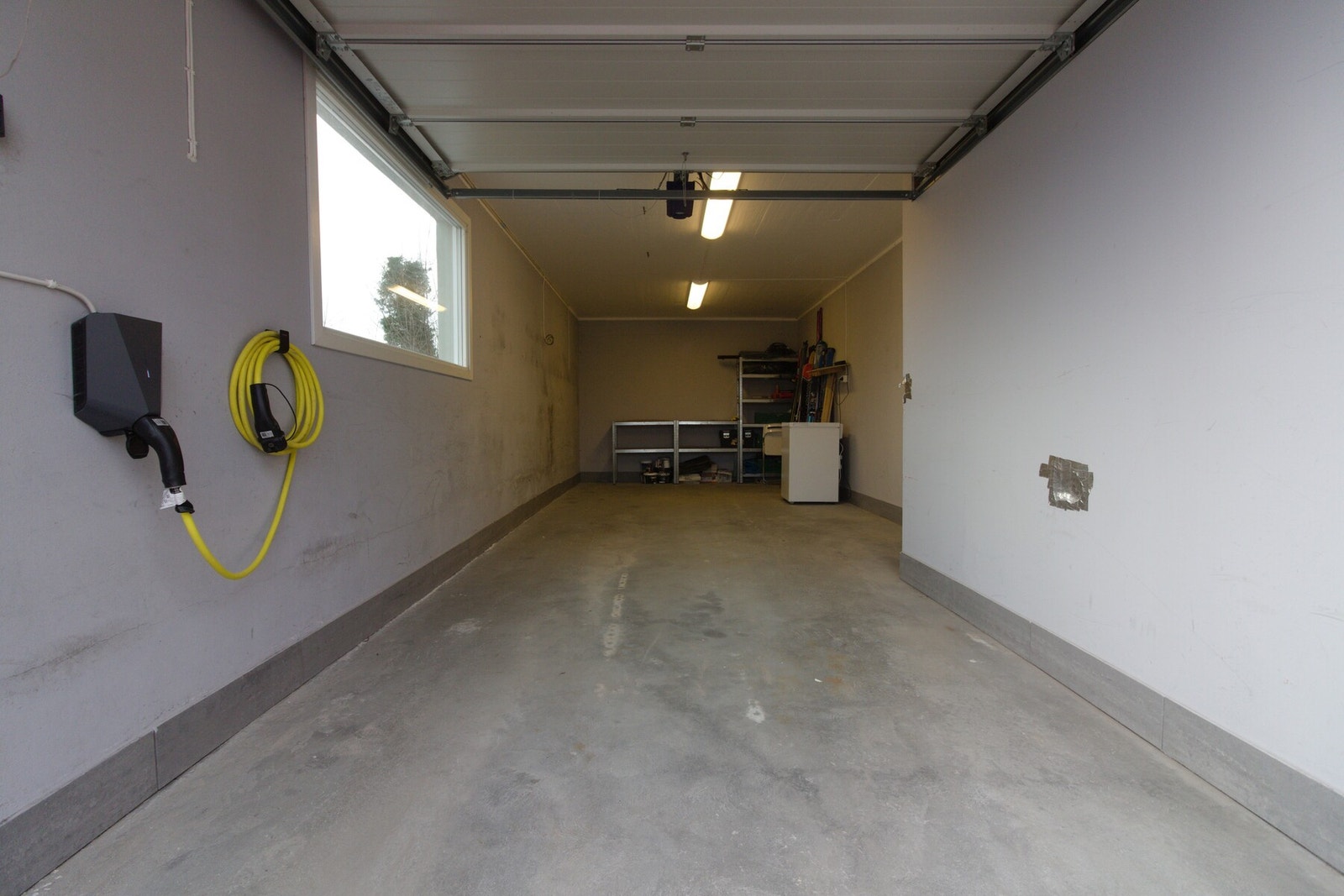 Garasjen har et areal på ca. 26 kvm. Det ble montert el-bil lader i garasjen i 2023. Galleribilde