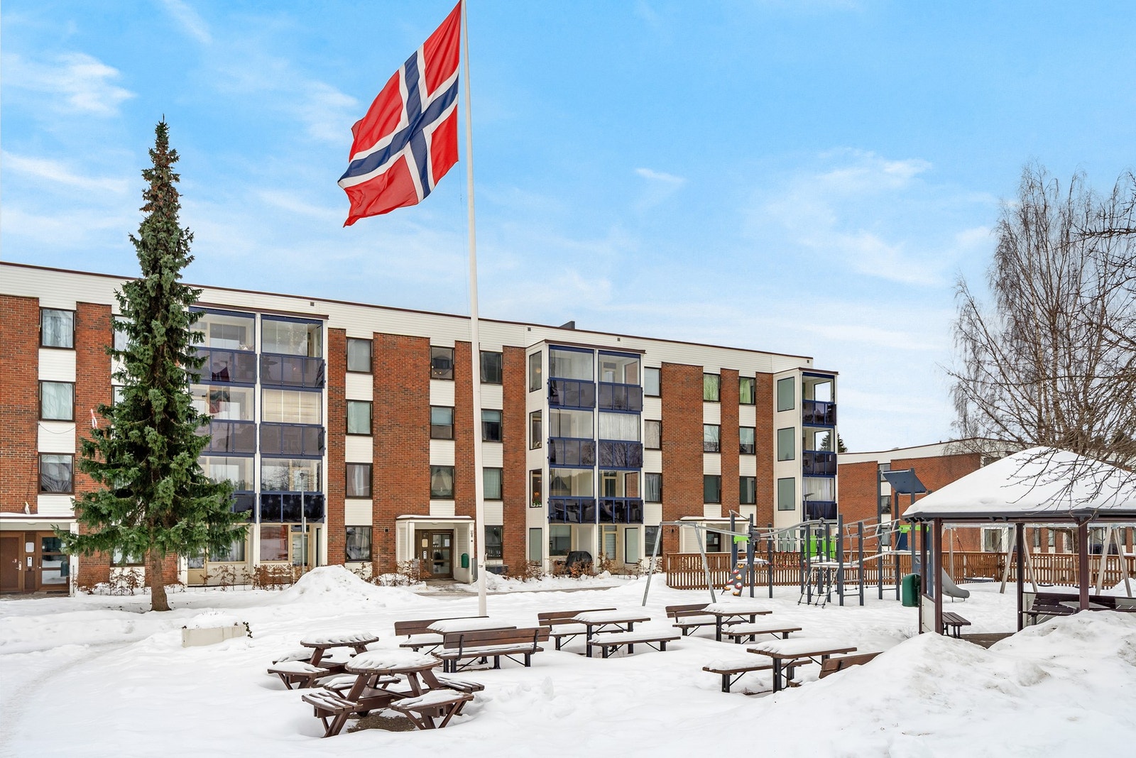 Felles uteområde med sittegrupper og lekeapparater. Galleribilde