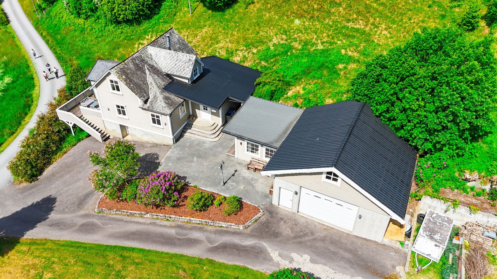Eiendommen er bebygget med enebolig, samt garasje med gjestestue og dritsbygning høyere i bakken. Galleribilde