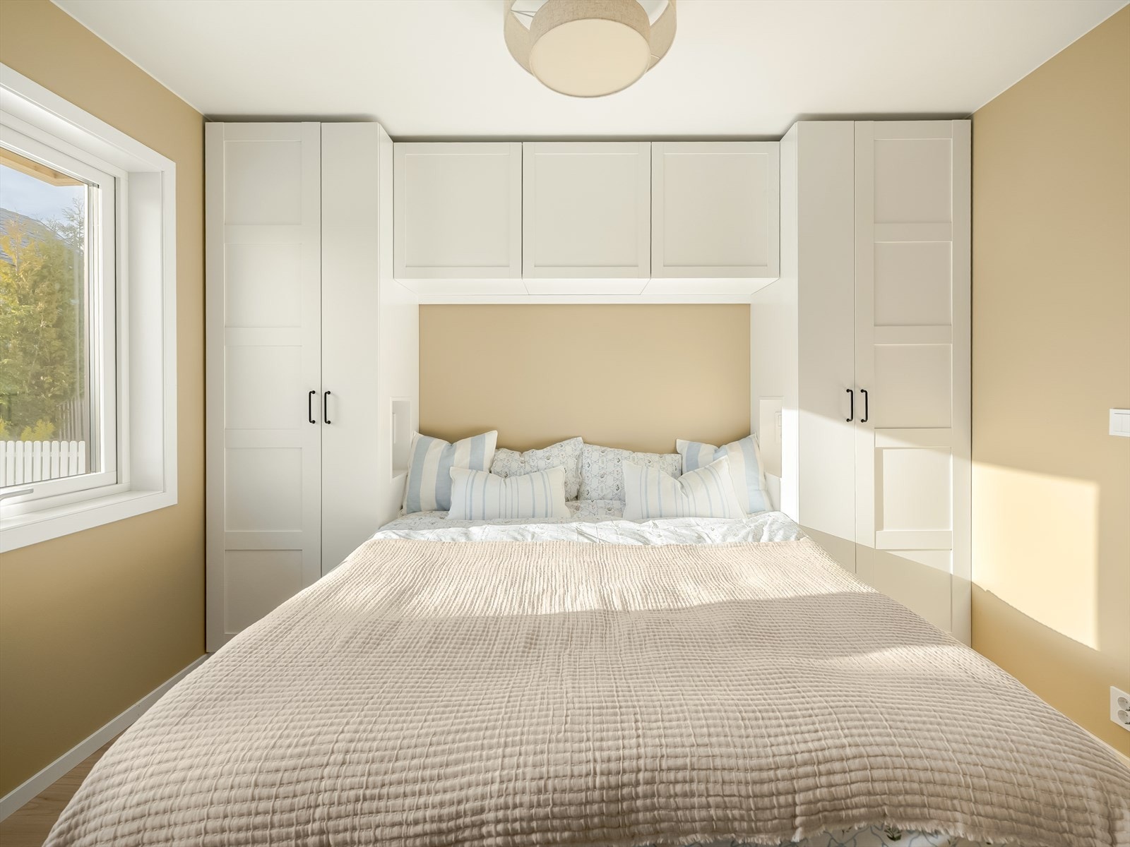 Store vinduer gir rikelig med naturlig lys, mens den nøytrale fargepaletten og lyse gulvet skaper en rolig atmosfære - perfekt som hovedsoverom, gjesterom eller et behagelig kontor. Galleribilde