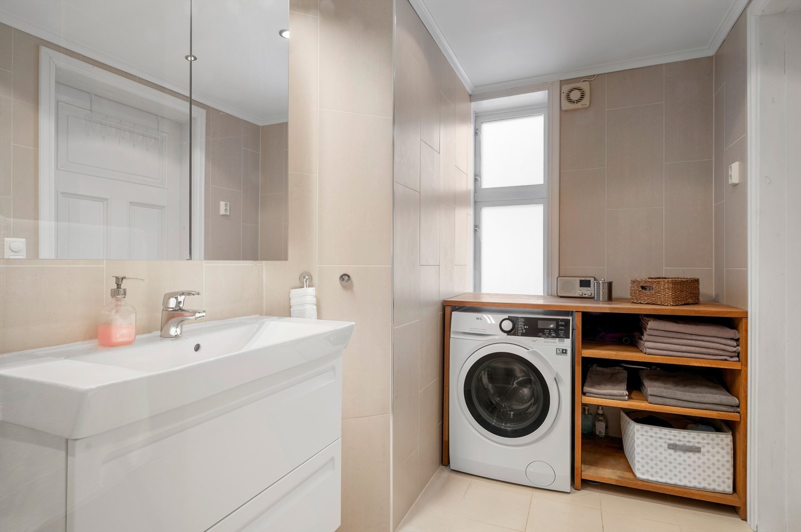 På badet er det innredet med dusjvegger av glass og dusjgarnityr på vegg, veggmontert toalett, innredning med servant, opplegg for vaskemaskin (Kran og
avløp) Galleribilde